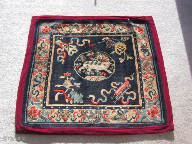 Tibetan: A pair of large mats, 32 by 36 inches, with prancing and naively drawn central snow lions surrounded by the "three Fruits" and a symbol of scholarly accomplishment. c.1930   
