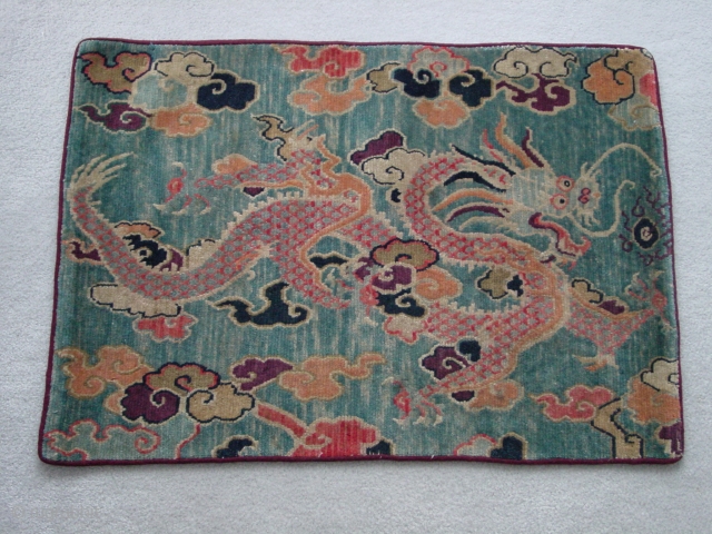 Tibetan dragon mat. Vibrant, folksy dragon in clouds on an abrashed blue ground, c.1920 Nick Wright                 