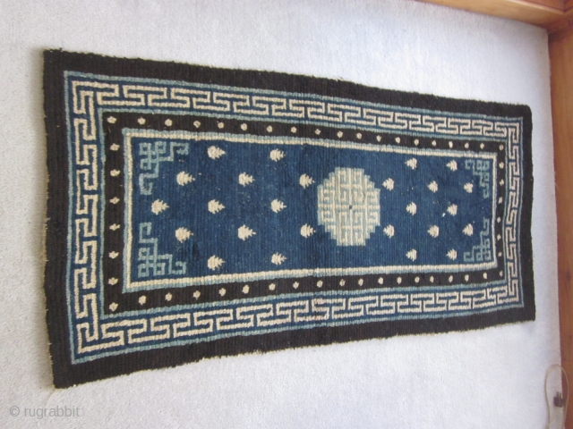 Tibetan: Vintage khaden, 2'3" by 4'6", with latch hook central medallion in light blue and frog's feet on a saturated indigo ground, before 1900. Some scattered re-piling.      