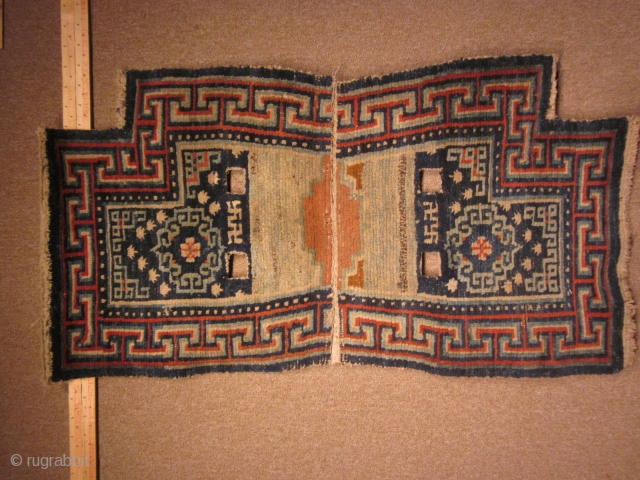 Tibetan: Archaic, and classic notched saddle bottom with asymmetric orange decoration where the two halves join, pre-1900 
               