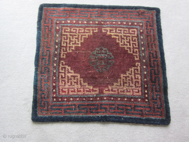 Tibetan sitting rug, 26 by 28 inches, natural colors on dark side, with some strong purply reds, pre 1900              