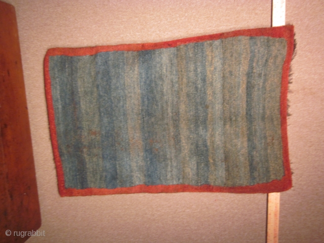 Tibetan, small khaden with abrashed blue green ground, with eccentric red border, 29 by 44 inches, pre-1900                