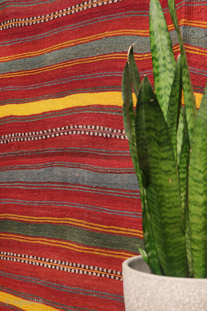 An antique kilim woven by an Uzbek weaver from Northern Afghanistan. The harmonious composition is achieved through the combination of wide plain bands with narrower bands decorated with small floral motifs, their  ...