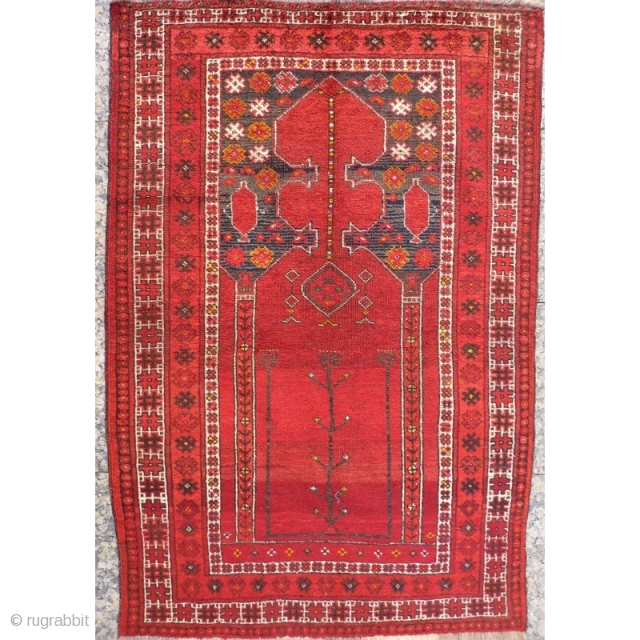 This prayer rug has a more formal border that constrasts with an unusual mihrab surrounded by two water jugs and randomly scatered motives. Tightly woven with nice shinny wool. The area where  ...