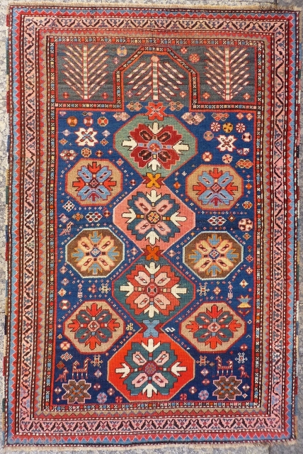 A Kuba rug with very vibrant natural colours and a nice design. The formality of the border and the mihrab contrasts with the introduction of animals and geometric floral motives throught the  ...