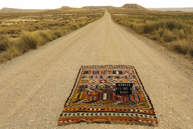 An antique Qashqai kilim woven with natural dyes. The design consists of motifs arranged in horizontal bands and combining multiple motifs. In both ends the kilim is finished with multiple borders. In  ...