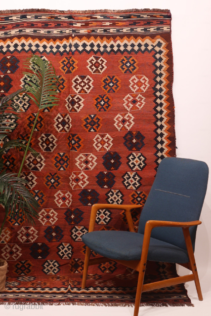 An antique Qashqai kilim woven with natural dyes. The wool is very finely spun. The pattern is arranged diagonally on a terracotta background with a beautiful abrash (colour changes). In mint condition.  ...