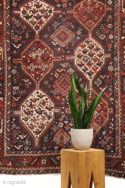 An antique Khamseh rug with a wonderful design and a very practical, almost square size.
The rug features two sets of medallions, each filled with numerous birds. These birds are repeated throughout the ...