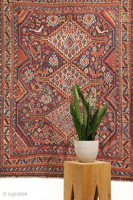 An antique Khamseh rug featuring three large medallions arranged horizontally, extending almost to the rug’s borders. The deep navy-blue field is richly decorated with birds, botehs, S-shaped motifs, and delicate vegetal elements.

The  ...