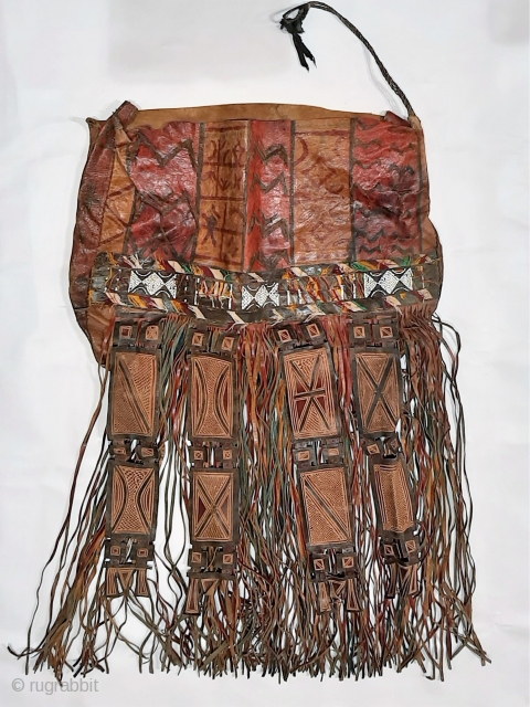 Tuareg leather womans travel bag ("aghrig"), with hand worked and dyed leather, probably goat skin. Intricate leather work with check pattern cut into dyed skin and embroidered thread patterns. The green dyed  ...