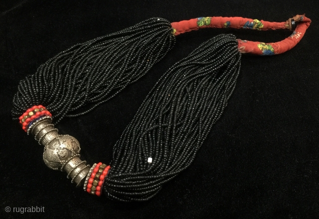 Tribal antique woman necklace from Indus
kohistan valley of Pakistan. The central large bead is silver
while the numerous strands of black beads are glass beads.         