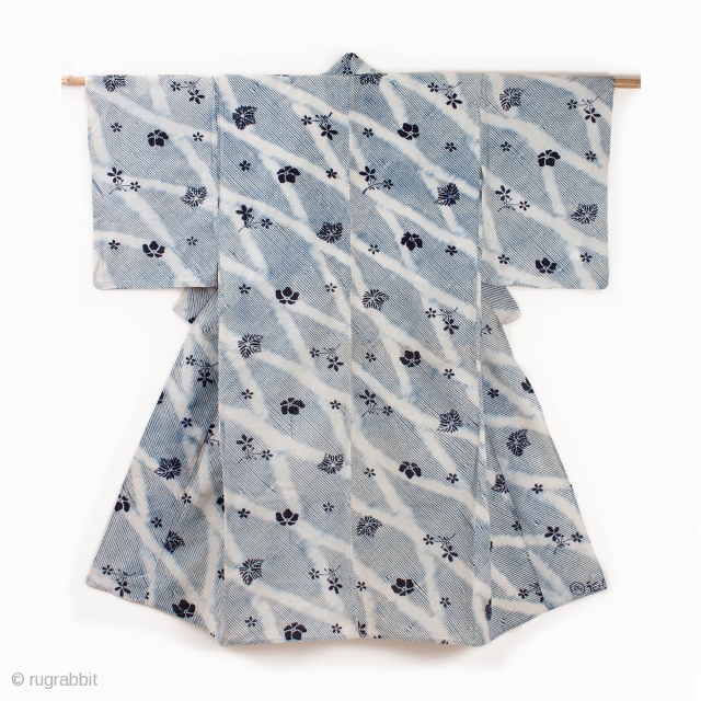 This is a shibori yukata. The shibori process is arashi shibori, where the cloth is wrapped around a pole and then dyed. Then the cloth was further dyed via katazome. The floral  ...