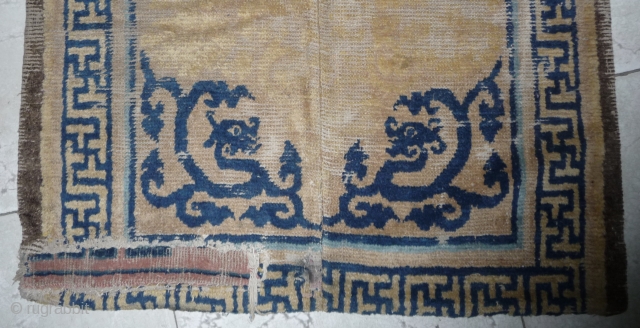 early foliated dragon fragment from a great 17th c ningxia rug. this fragment shows the original length of the piece but has been reduced in width. bad condition around the dragons. china. 