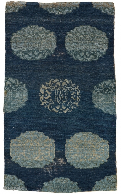 This evocative Tibetan khaden, or sleeping rug, draws large stylized peonies inspired by Chinese textile design of the Ming and Ching dynasties against a transplendent indigo field. While a repeat design is  ...