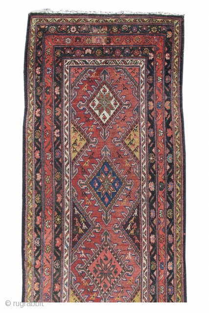 This colorful runner was woven in Persia, in the vicinity of Hamadan. A column of colorful diamonds, articulated with arrowhead motifs, is drawn against a brick red ground. Eight-pointed stars are rendered  ...