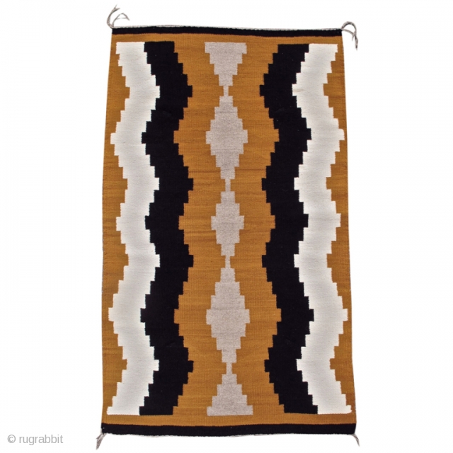 This simple small vintage mid 20th century Navajo rug paints waves of natural ivory and brown to form subtle intimations of side-borders. A column of grey diamonds is drawn along the center  ...