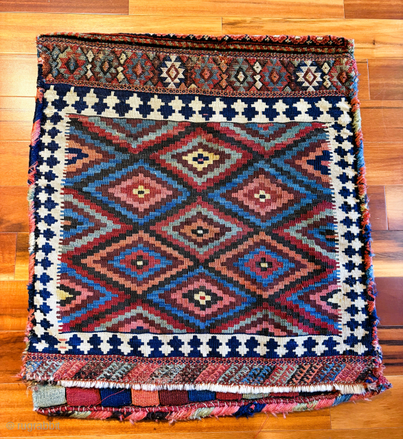 Late 19th C. Kurd bag, 25" x 26", featuring a beautifully drawn multicolored flat woven back, and a sumptuous naively drawn pile face. Possibly a dowry piece as it doesn't appear ...