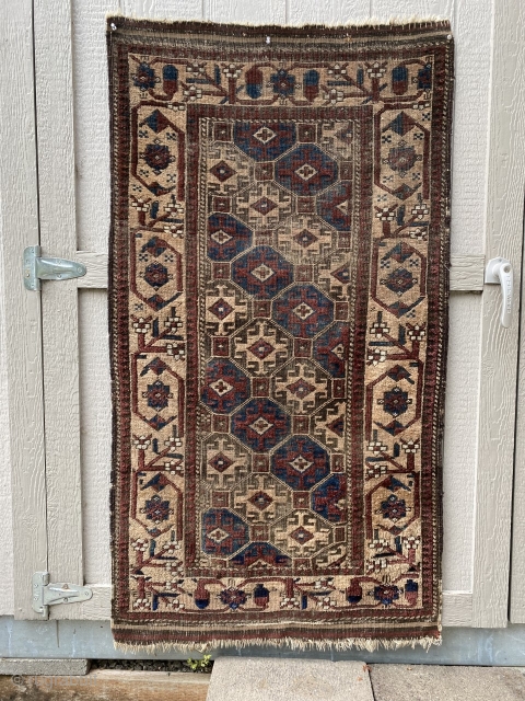 Circa 1900 Baluch camel hair rug, 2'10" x 5'4".  Nicely drawn lattice field pattern with a clear blue in alternating diagonal bands. Areas of wear in the field (see photo).   ...