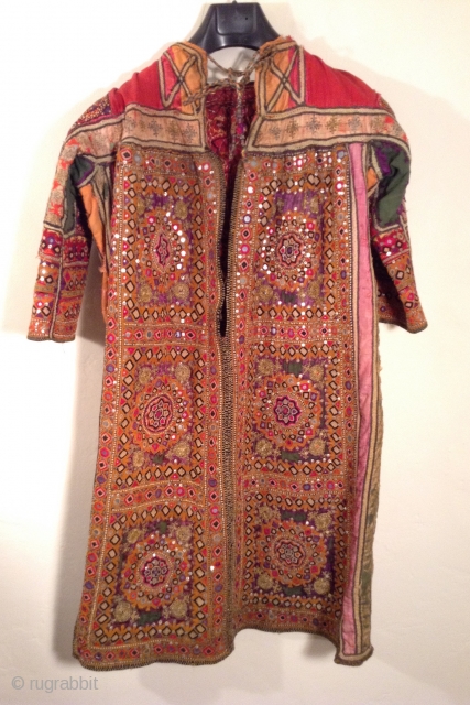 This is a wonderful embroidered dress from Rajasthan, India.  The embroidery covers all of the fabric except for the neckline and several strips of Satin fabric under the arms.  Some  ...