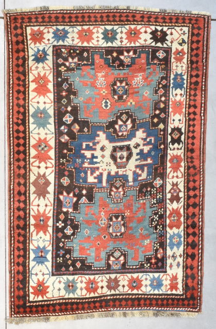 This third quarter 19th century Kazak Oriental rug #8199 measures 4‘3“ by 6‘5“. It has three Shirvan stars in the center, one blue with an ivory center flanked by two green stars  ...