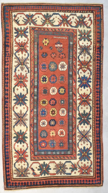 This circa 1880 Kazak Rug #8203 measures 3‘6“ by 6‘5“. It is a so-called ‘Star Kazak’. It has a red ground with nine small white crosses at the bottom of it and ...