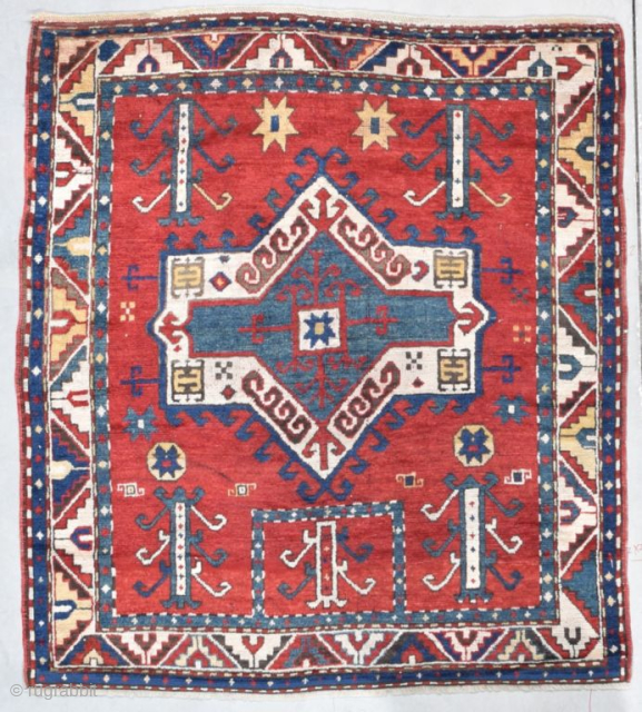 This third quarter 19th century Facralo Kazak antique Caucasian Oriental rug measures 4’3” X 4’9”. It has a six pointed star center medallion in red, ivory, and blue on a tomato red  ...