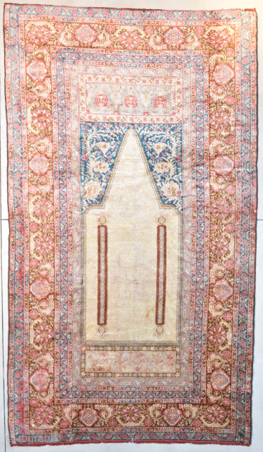 This 3rd quarter 19th century Angora Oushak Oriental Rug #8119 measures 6’7” X 11’6”. The prayer design is in ivory containing two columns in rust with a bulbous design at either end  ...