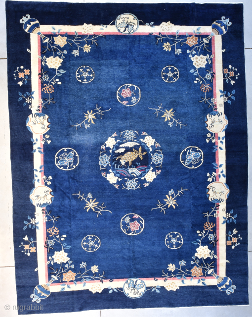 This circa 1900 Peking Chinese Oriental Rug #8193 measures 9‘3“ x 12‘0“. It has a medium blue field surrounded by a dark blue border. The motif and the field contain eight circles  ...