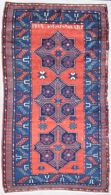 This Armenian Kazak antique Caucasian Oriental #8103 rug dated 1913 measures 3’9” x 6’8” has a red ground with an an inscription and three 8 pointed stars running up the field displaying  ...