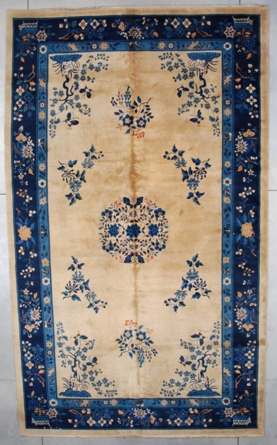 This very lovely, circa 1930 oversized Peking Chinese Oriental rug measures 10’0” x 16’9” (304 x 515 cm). It has an old ivory colored field with a center medallion consisting of a  ...