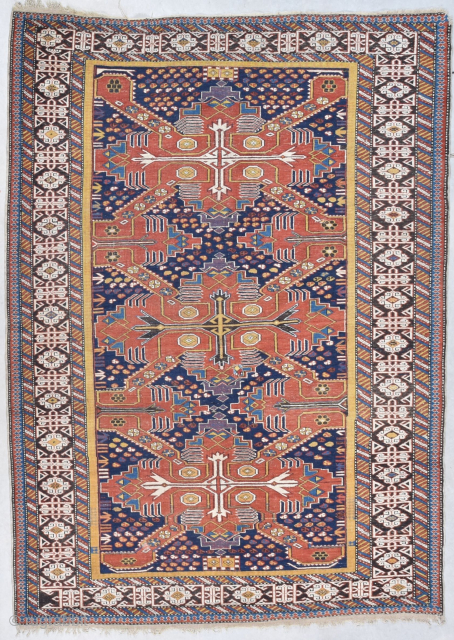 This circa 1880 Shirvan/Kuba #7995 measures 4’7” X 6’4”. It has three tomato red Saint Andrews crosses on an indigo ground. The ground is covered in quartered octagons in ivory, tobacco, two  ...