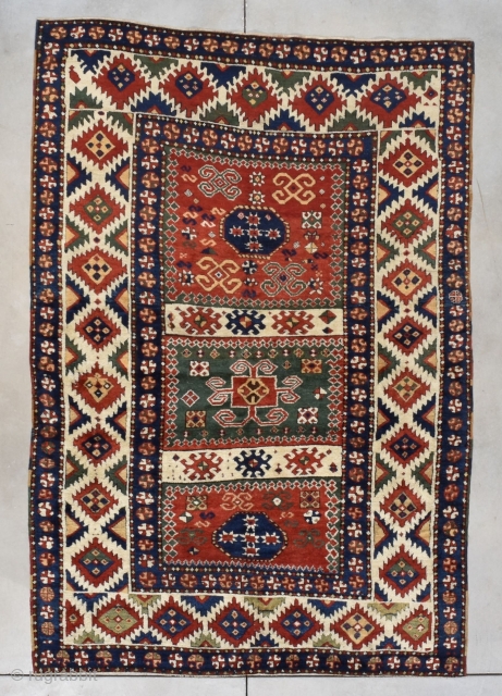 This third quarter 19th century Borchalou Kazak #7775 antique Oriental Caucasian carpet measures 5’2” X 7’5” (158 x 229 cm). The three panel field consists of two red squares flanking a green  ...