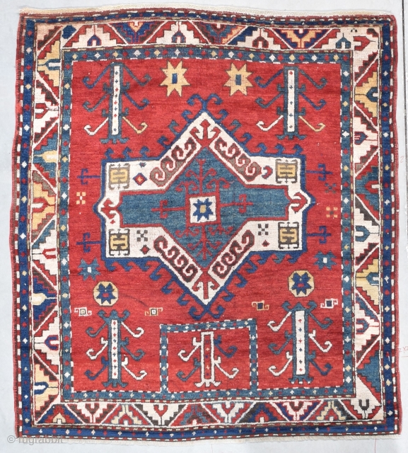 This third quarter 19th century Facralo Kazak #8102 antique Caucasian Oriental rug measures 4’3” x 4’9”. It has a six pointed star center medallion in red, ivory, and blue on a tomato  ...