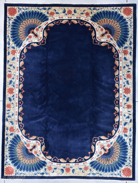 This circa 1920 Art Deco Chinese Oriental Rug measures 8’9” X 11’7”. It has a dark indigo blue field with a meandering vine and leaf border with huge red chrysanthemum flowers. Each  ...