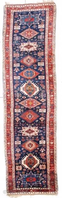 This circa 1850 antique Karadan Kazak Oriental rug runner #6453 measures 3’8” X 13’6”. It has eleven different shaped, sized and colored medallions on a dark blue field with a rust border  ...