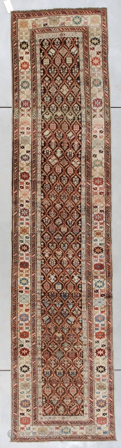 #7414 Kuba Antique Caucasian Rug Runner 3’2″ x 13’2″ This is an interesting long rug. It has a latticework design containing innumerable different flower motifs worked in gold, pale blue, and red  ...