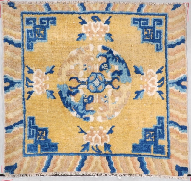 This circa 1860 Ningxia meditation mat #7286 measures 2’0” x 2’1” (60 x 64cm). It has a mustard ground with Chinese fretwork in blue in the corners. The border has a wave  ...