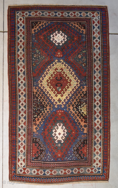 This circa 1880 antique Caucasian Kazak Oriental Rug #8232 measures 3 foot 10 inches by 6 foot 9 inches. It has three latch hook medallions. The one in the middle is red  ...