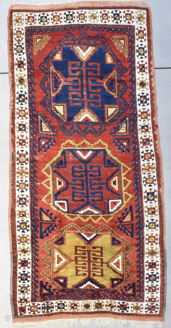 This circa 1880 Kazak Antique Oriental Rug #8192 measures 4‘4“ by 9‘0“. The design consists of three octagons in blue, red and yellow green on a red ground. It has an ivory  ...