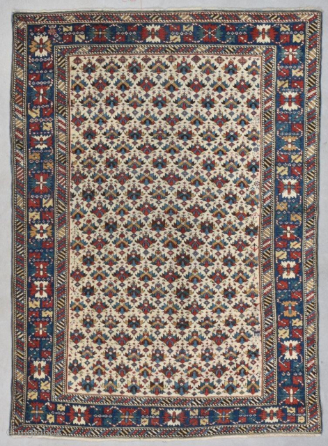 This circa 1850 antique Kuba Oriental Rug #7742 measures 3’8” X 5’1” (116 x 155 cm). It has an ivory ground completely covered in a combination of shield and palm head design  ...