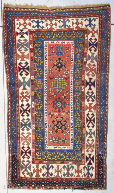 This third quarter 19th century Kazak Oriental rug #8200 measures 3‘3“ by 5‘11“. It has a rectangular center field in red, which is filled with asymmetric motifs of different shapes, sizes and  ...