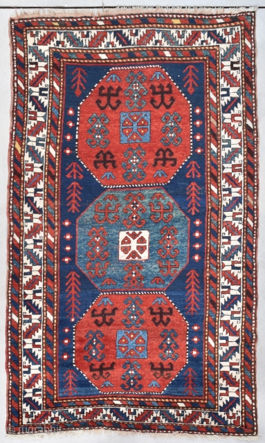 #7734 Kazak Antique Caucasian Rug 4’7″ x 7’8″ This circa 1880 Kazak Oriental Rug measures 4’7” x 7’8” (143 x 237cm). It has a dark blue ground with three eight sided medallions.  ...