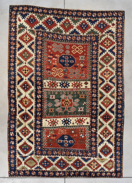 This third quarter 19th century Borchalou Kazak #7775 antique Oriental Caucasian carpet measures 5’2” X 7’5” (158 x 229 cm). The three panel field consists of two red squares flanking a green  ...
