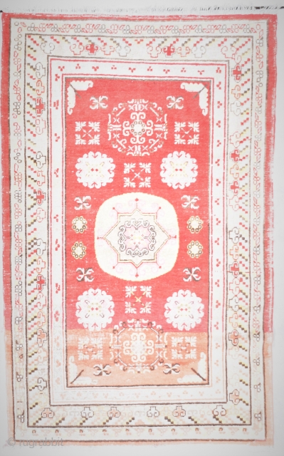 This circa 1900 Khotan Antique Oriental Rug measures 4’0” X 6’5”. It has a center medallion consisting of an eight pointed star outlined in Khotan pink. The upper and lower corners of  ...