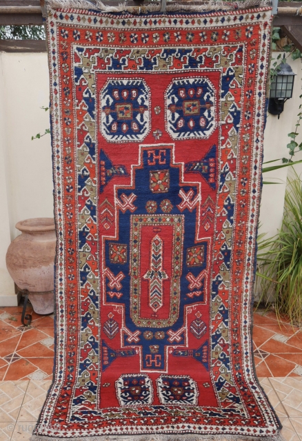 An East Anatolian village rug, (7.6ft x 3.5ft.) with distinctive Caucasian characteristics with a Kuba-Konagkend stepped medallion, framed by a stylised bird border. Two amulet motifs placed a-symmetrically at each end. Around  ...