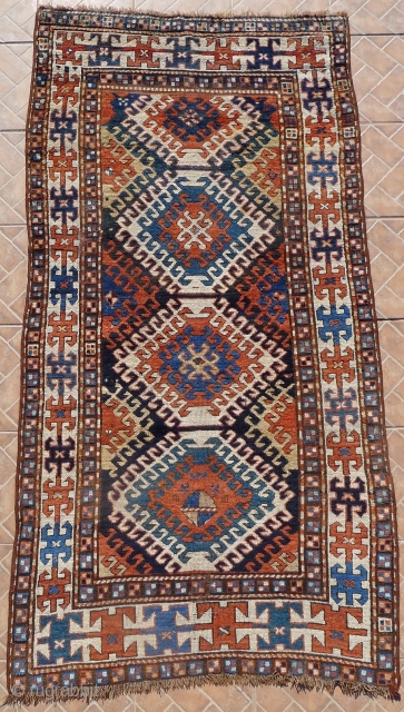 Kazak Rug, Bordjalou region, SE Caucasus, 215 x 11 cm. (7.05ft x 3.7ft) Probably 3 rd. qtr. of 19 th century. The design with a column of latch-hooked diamonds on a dark  ...