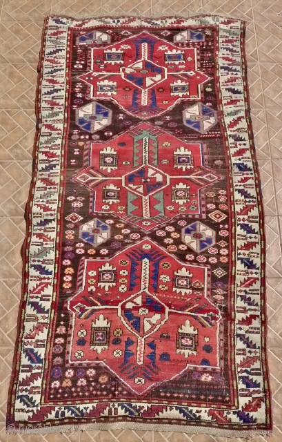 Kazak with Akstafa medallions, Bordjalou region.  124 x 240 cm. Around 1900. Nice condition with slight corrosion of the dark brown ground.          