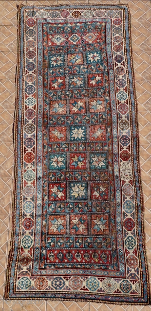 A Genje long rug with star design, late 19 th. century, 
Size:  306 x 120 cm. (10ft x 4ft.)
Inscribed in the right border and dated 1290 AH/ 1873 AD
A few areas  ...