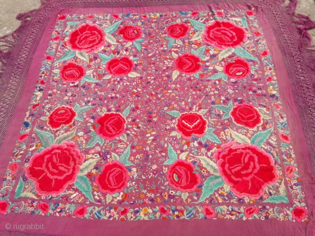 OLD SHAWL

5 1/2 foot square with 18" fringe containing diamond pattern.
Fushia silk crepe and silk knotted fringe
Covered with floral pattern with 12" and 6" diameter roses of 
hand satin stitch embroidery
2 1/2"  ...