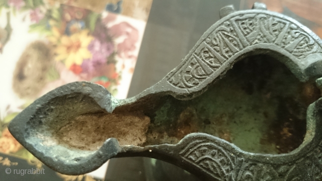 This is a cast bronze oil lamp from the Seljuq era in Khorassan, N.E. of Iran, ca. 12th century A.D. There is an inscription around the lid that I can not decipher.  ...